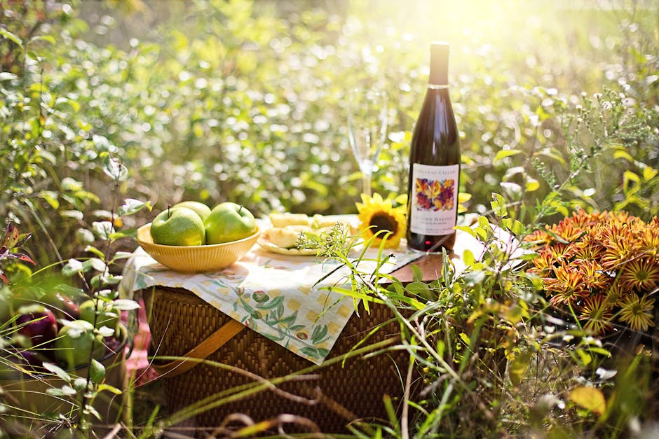 pexels photo 5359042 5359042 A scenic picnic setup with wine, fruits, and sunflowers in bright sunlight.